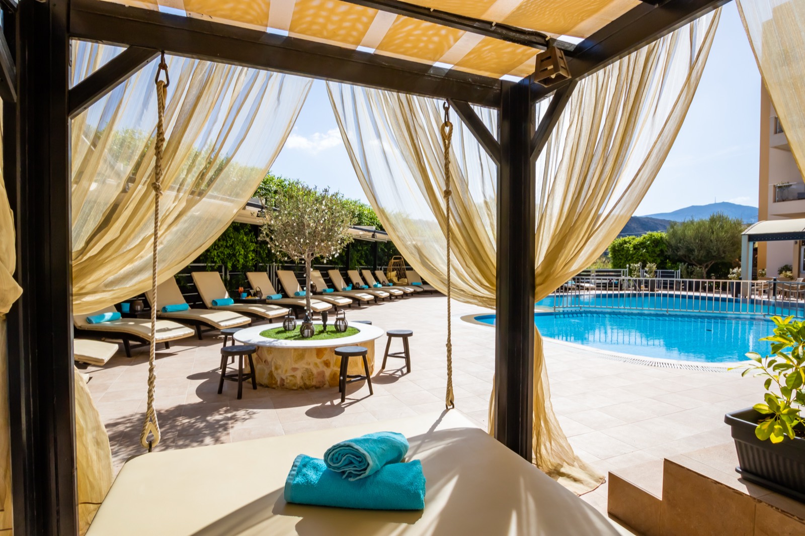 Shaded cabana with sheer curtains overlooking the pool