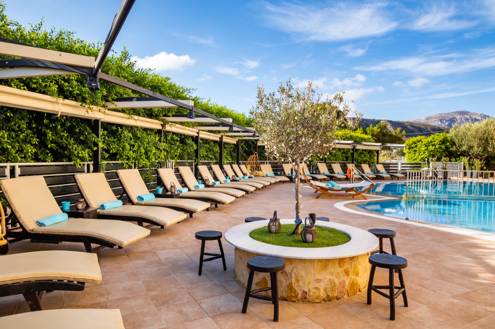 Sun loungers beside the olive tree fire pit
