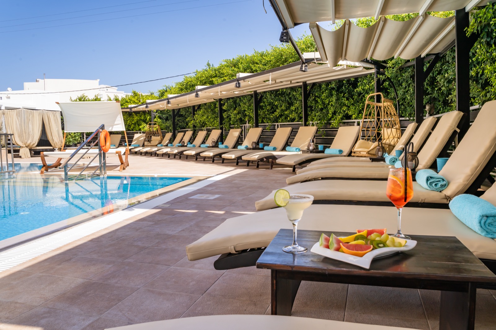 Poolside loungers with drinks and fresh fruit